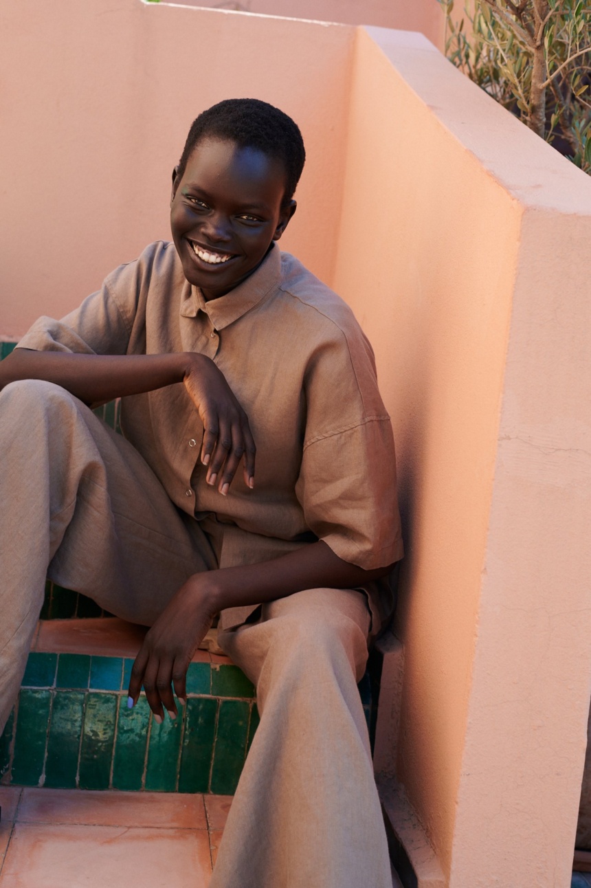 model wearing a linen set of short-sleeved linen shirt, and wide leg trousers in mocha mousse