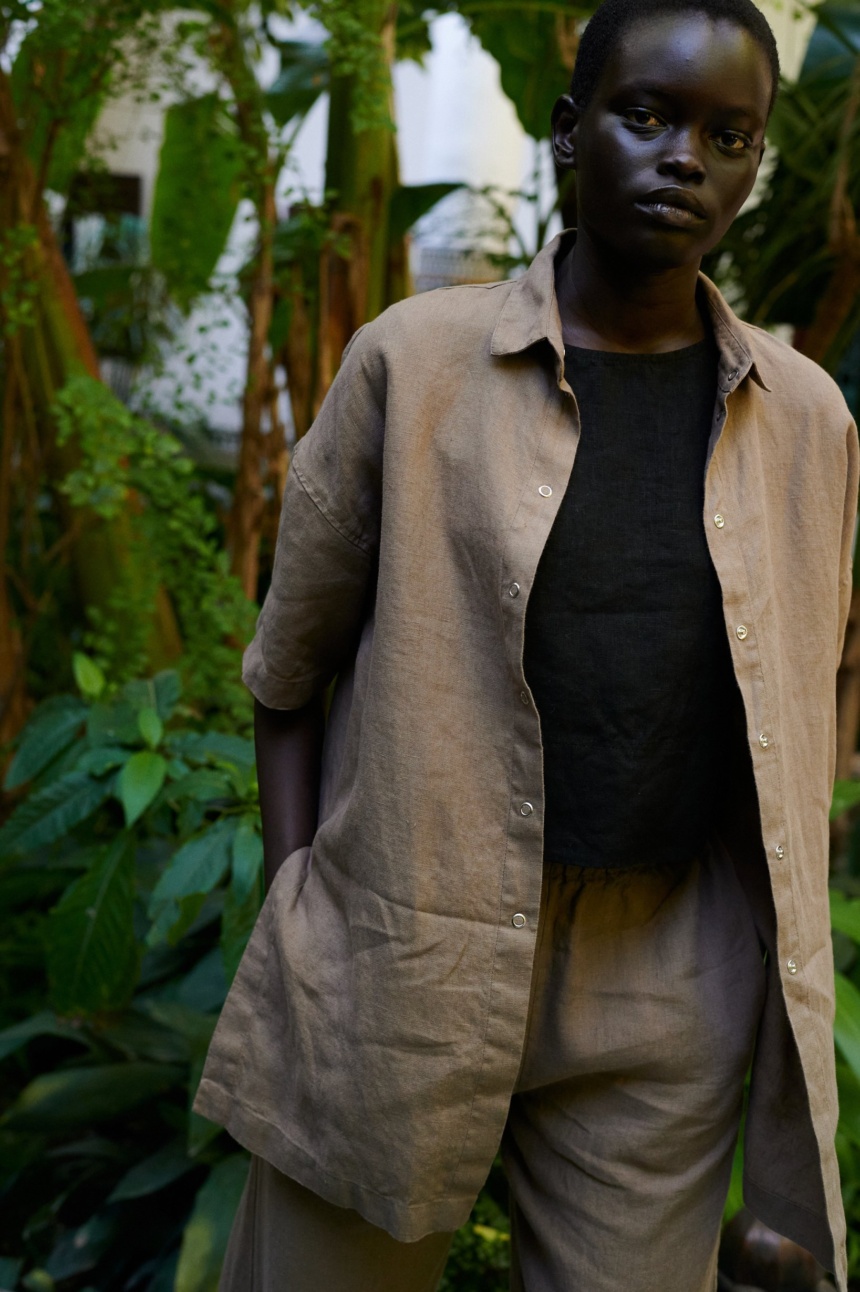 model wearing a summer linen set of short-sleeved linen shirt, and wide leg trousers in mocha mousse