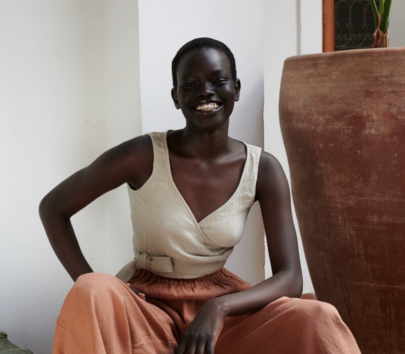 Waffle top made from textured linen with a wrap front, waist ties, and sleeveless cut. A cropped piece designed for warm weather styling.