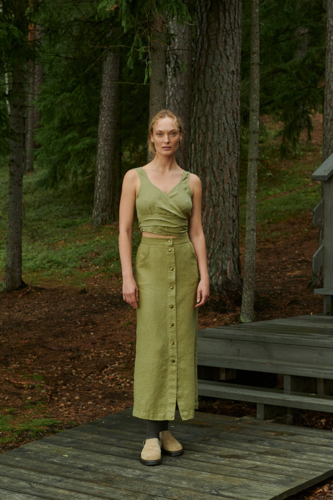 Woman wearing the Heidi heavy linen skirt in olive, paired with a sleeveless top – ideal for minimalist warm-weather looks