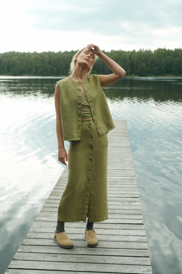 women is wearing button up maxi skirt in heavy olive linen