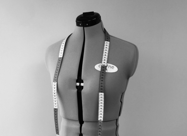 a sewing pattern and soft measuring tape showing the process before handmade linen garment making in black and white
