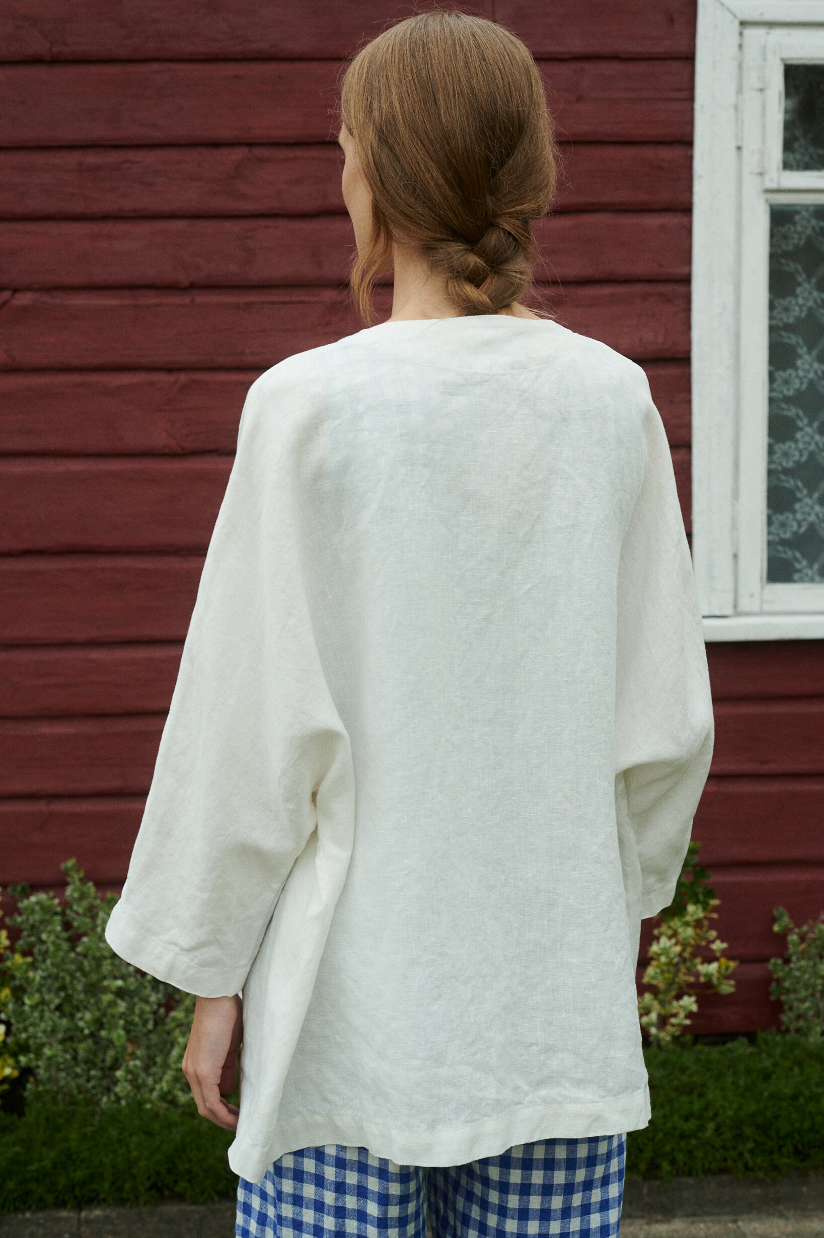 the back view of a model wearing milky white linen jacket