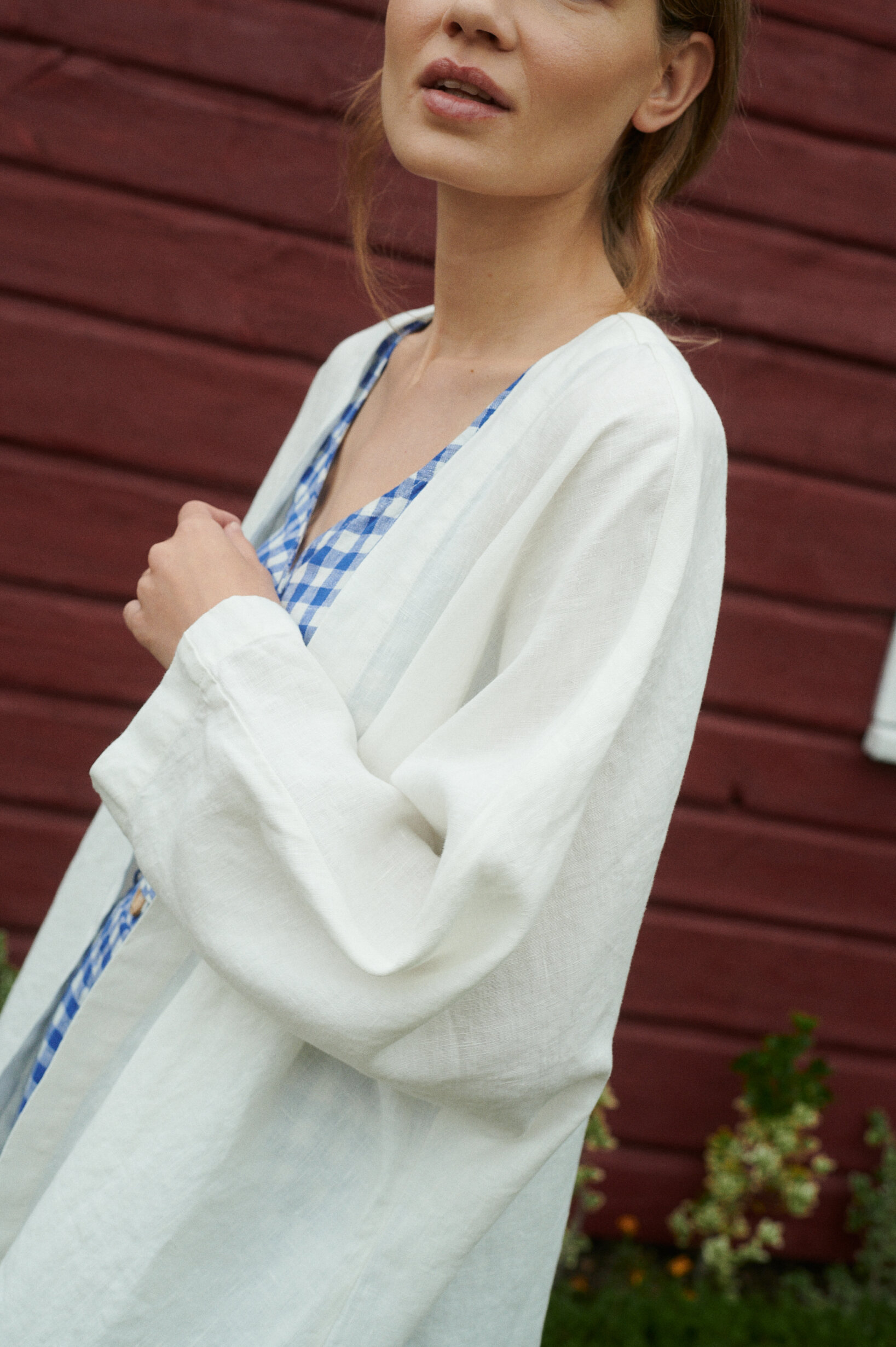 woman wearing blue gingham linen wrap top with an oversized linen jacket in milky white