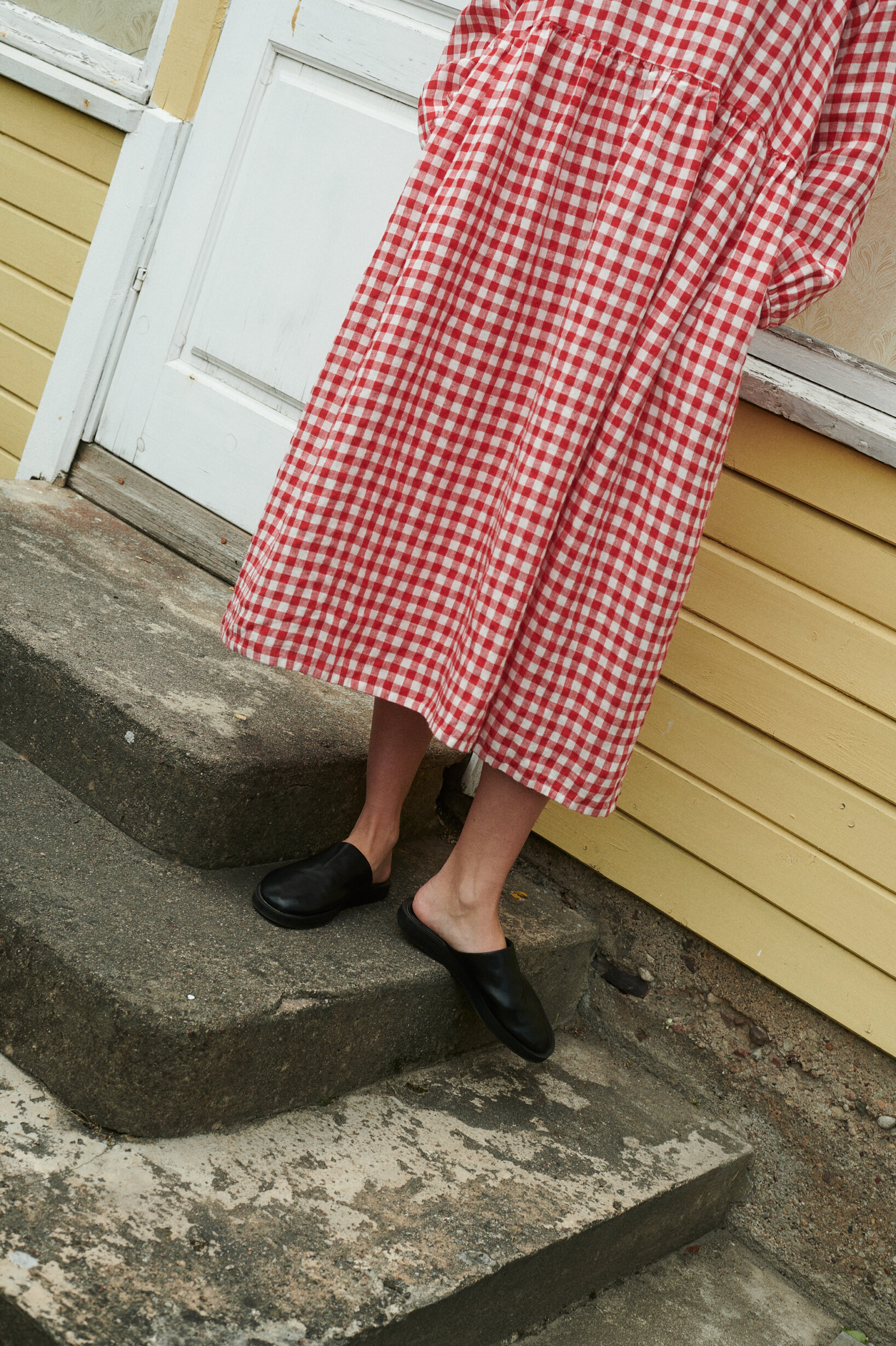 a close up shot of model wearing oversized red gingham linen dress