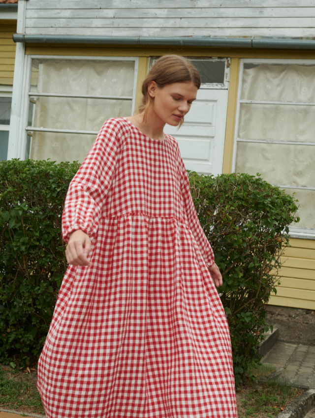 model wearing an oversized linen dress with full length sleeves in red gingham linen