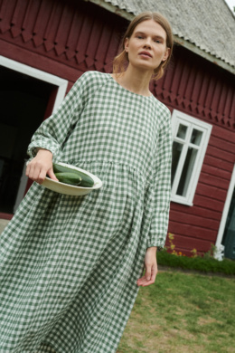 model wearing oversized linen dress in summer that is made from green gingham linen fabric