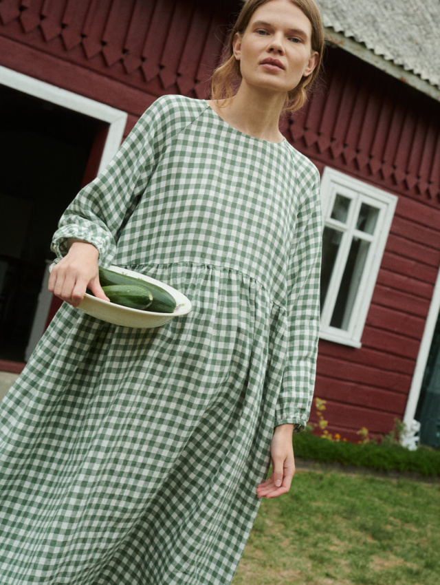 model wearing oversized linen dress in summer that is made from green gingham linen fabric