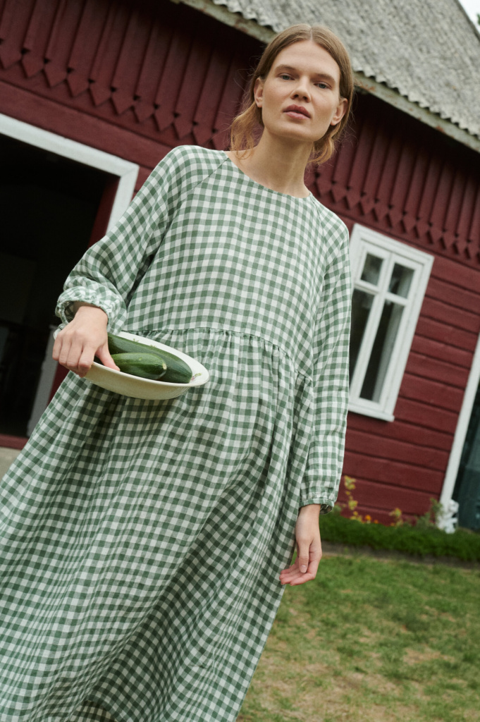 model wearing oversized linen dress in summer that is made from green gingham linen fabric