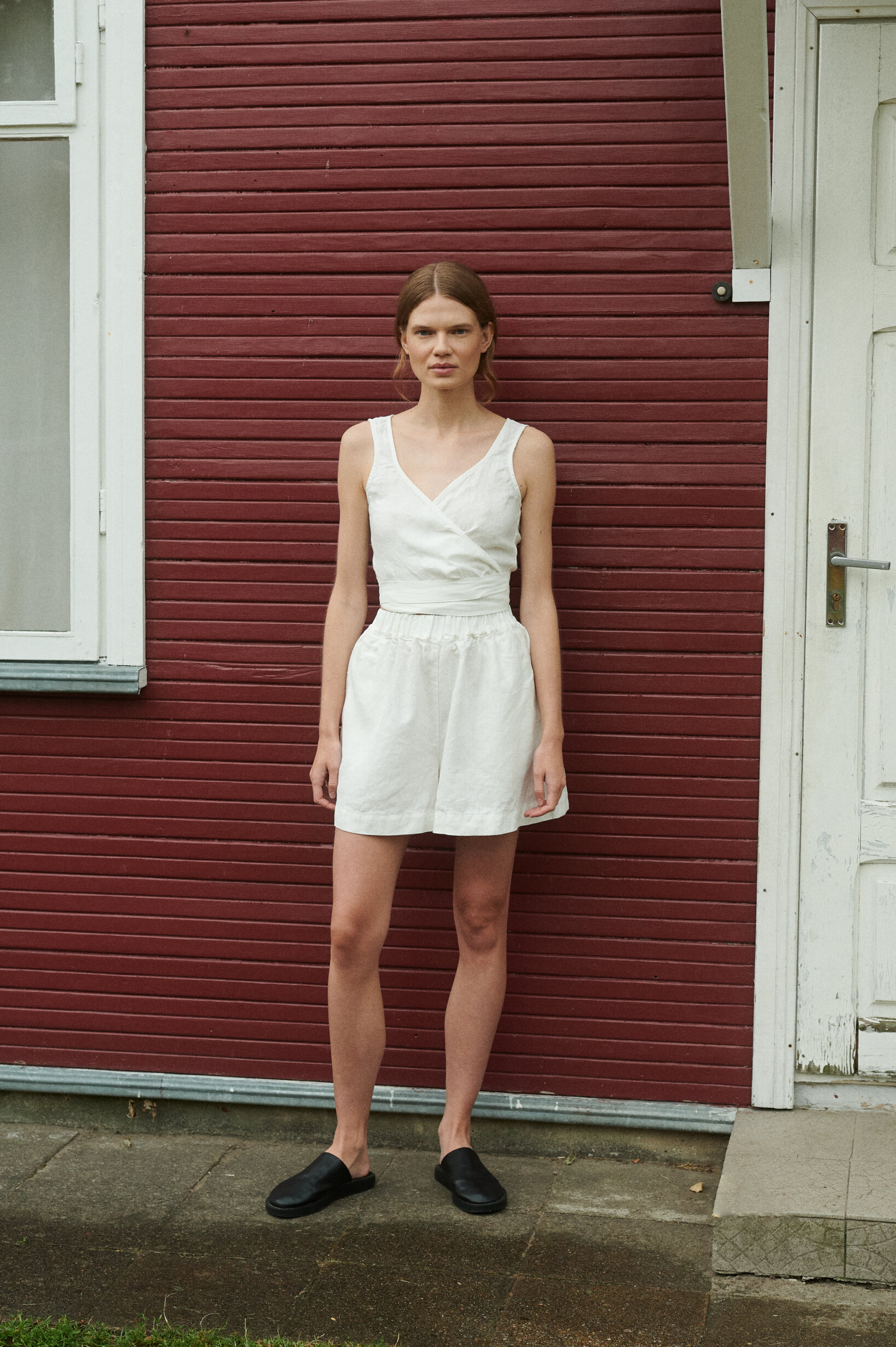 model wearing summer linen set in wide summer shorts and v-neck wrap top in milky white