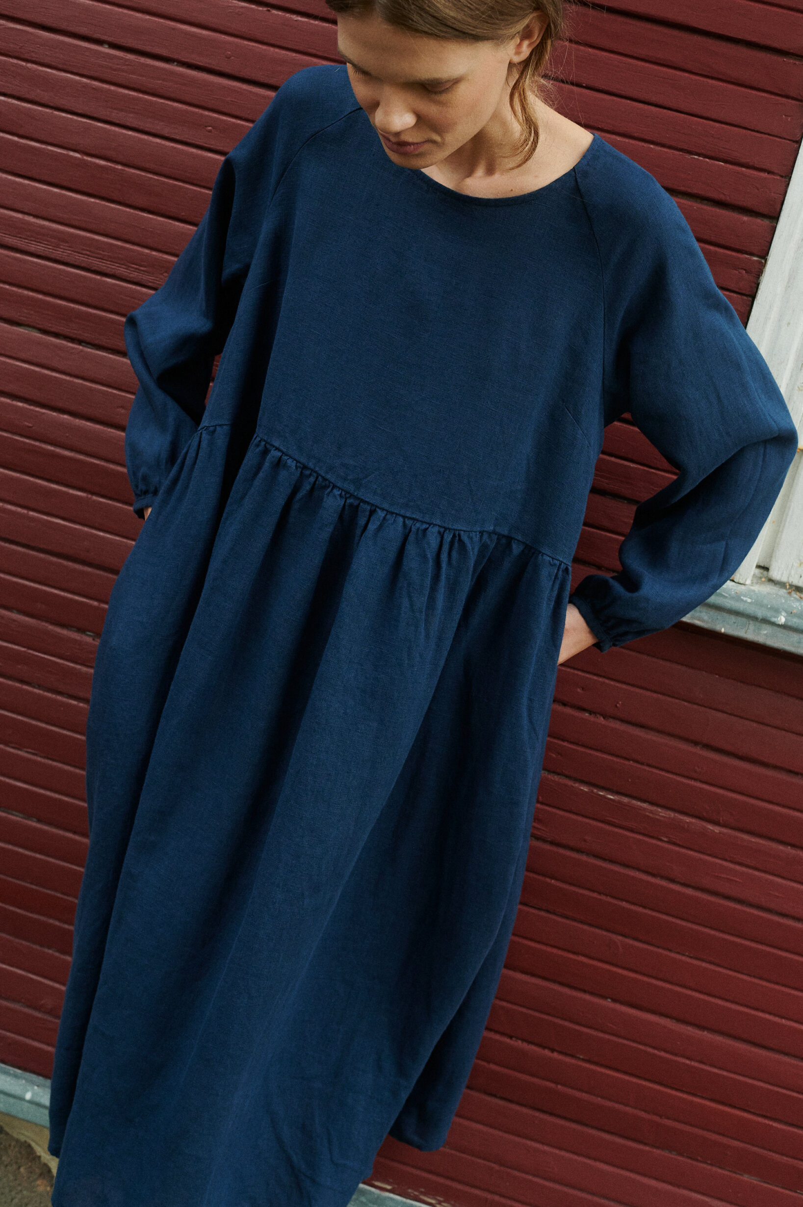 a close up of a woman model wearing oversized linen dress in navy blue natural linen