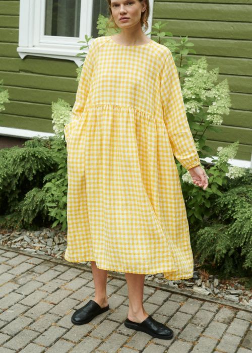 model posing with a yellow gingham linen dress in oversized fit and full length sleeves