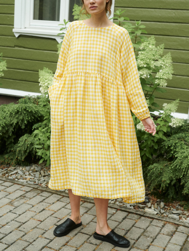 model posing with a yellow gingham linen dress in oversized fit and full length sleeves