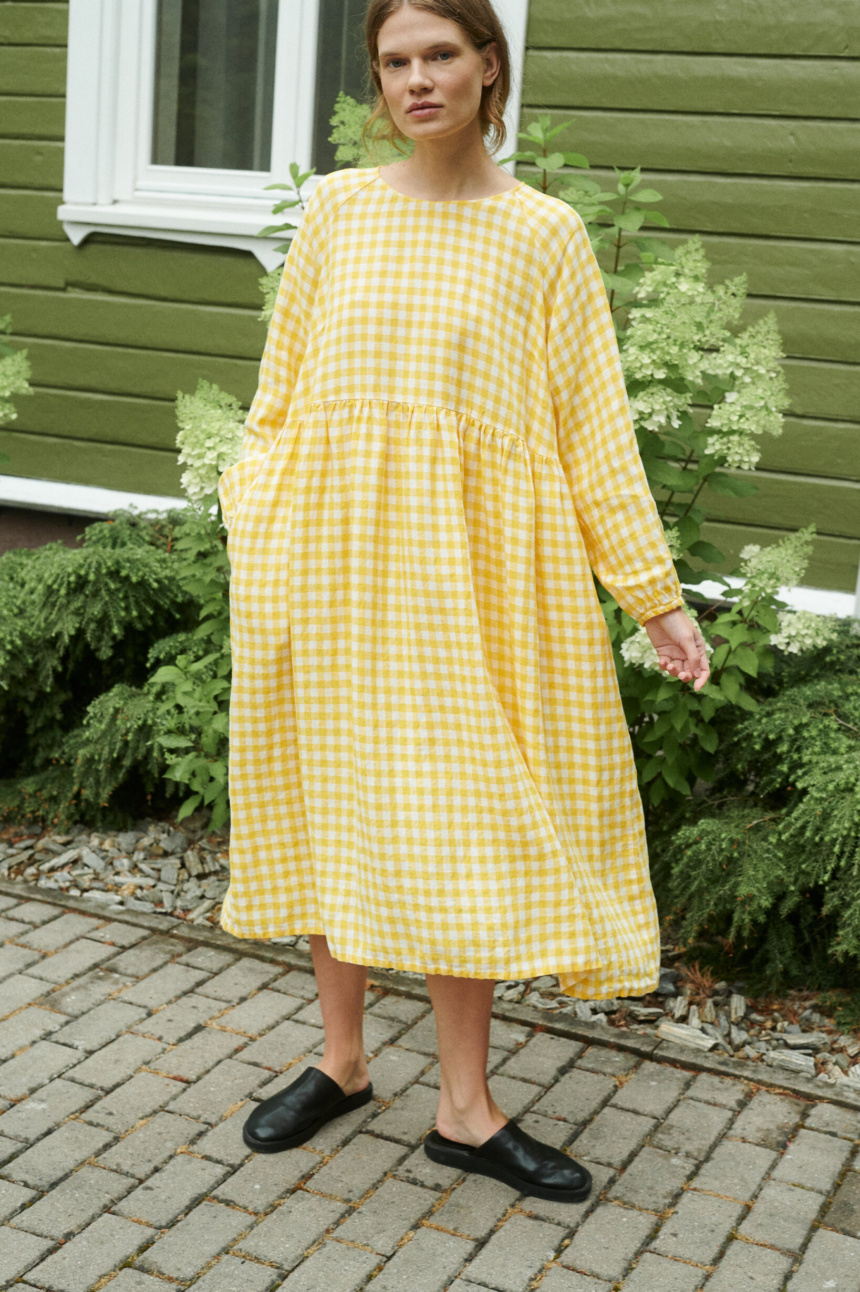 model posing with a yellow gingham linen dress in oversized fit and full length sleeves