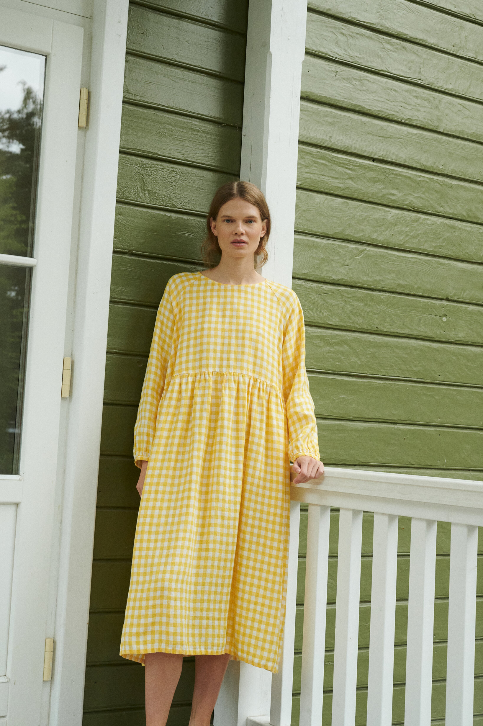 model wearing a yellow gingham linen dress in oversized fit and full length sleeves