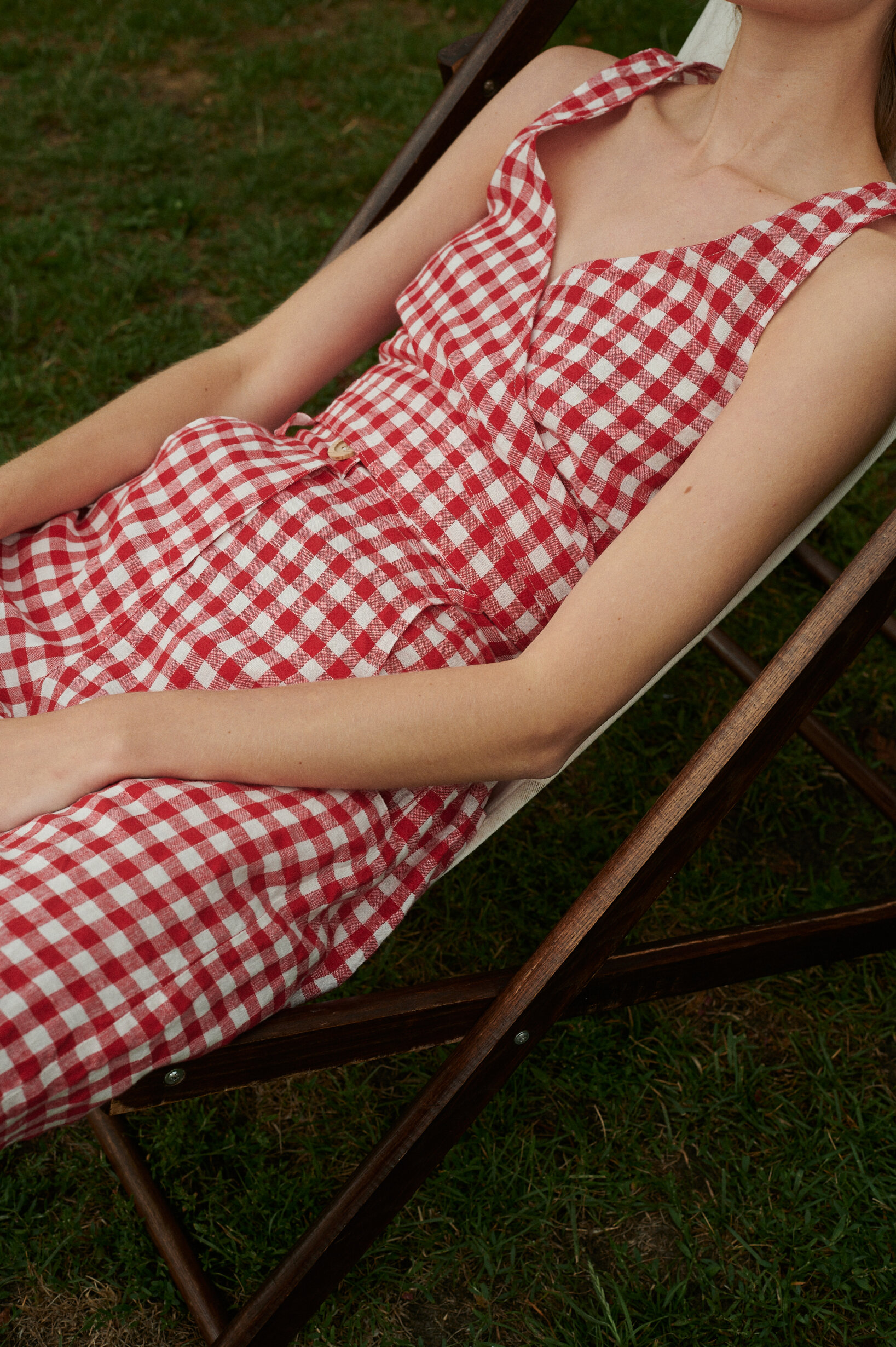 Model wearing summer linen set - V-neck wrap top and trousers in red gingham linen.