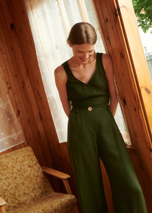 Model wearing waffle linen trousers and wrap top in forest green