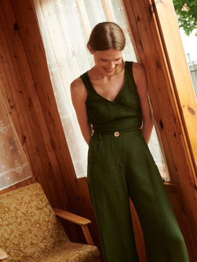 Model wearing waffle linen trousers and wrap top in forest green