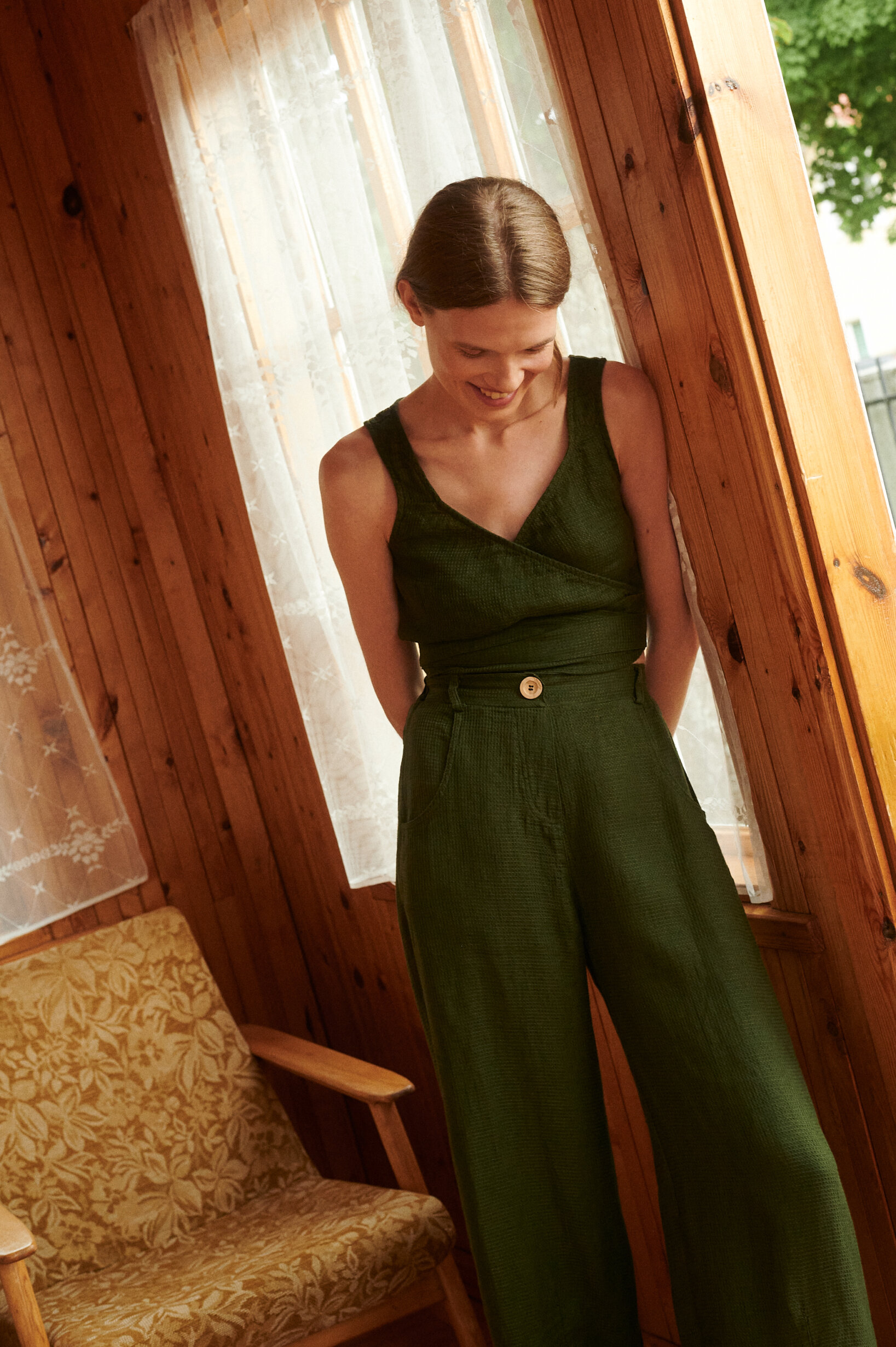 Model wearing waffle linen trousers and wrap top in forest green