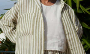 Woman in a lightweight oversized linen shirt with matching linen olive stripes shorts