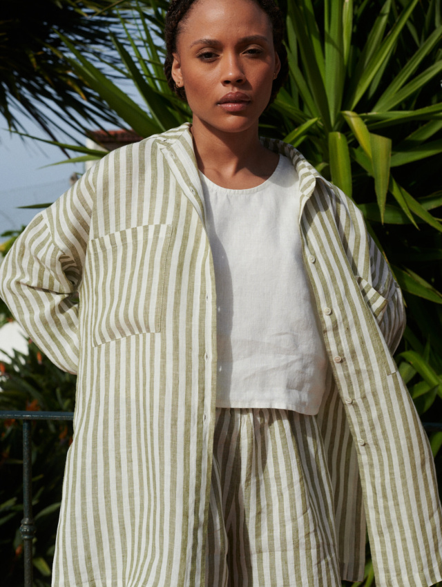 Woman in a lightweight oversized linen shirt with matching linen olive stripes shorts