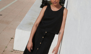 Model wearing a black midi skirt paired with a matching casual sleeveless linen top