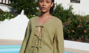 A woman draped in a tie-up front top and a short skirt in olive linen fabric,
