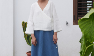 Model wearing an oversized white linen wrap top and a long blue linen skirt outfit