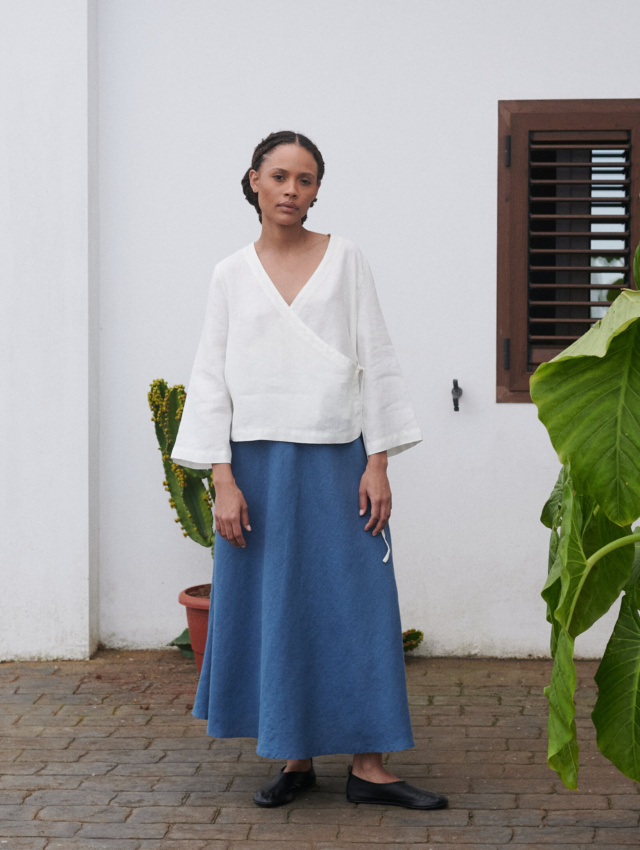 Model wearing an oversized white linen wrap top and a long blue linen skirt outfit