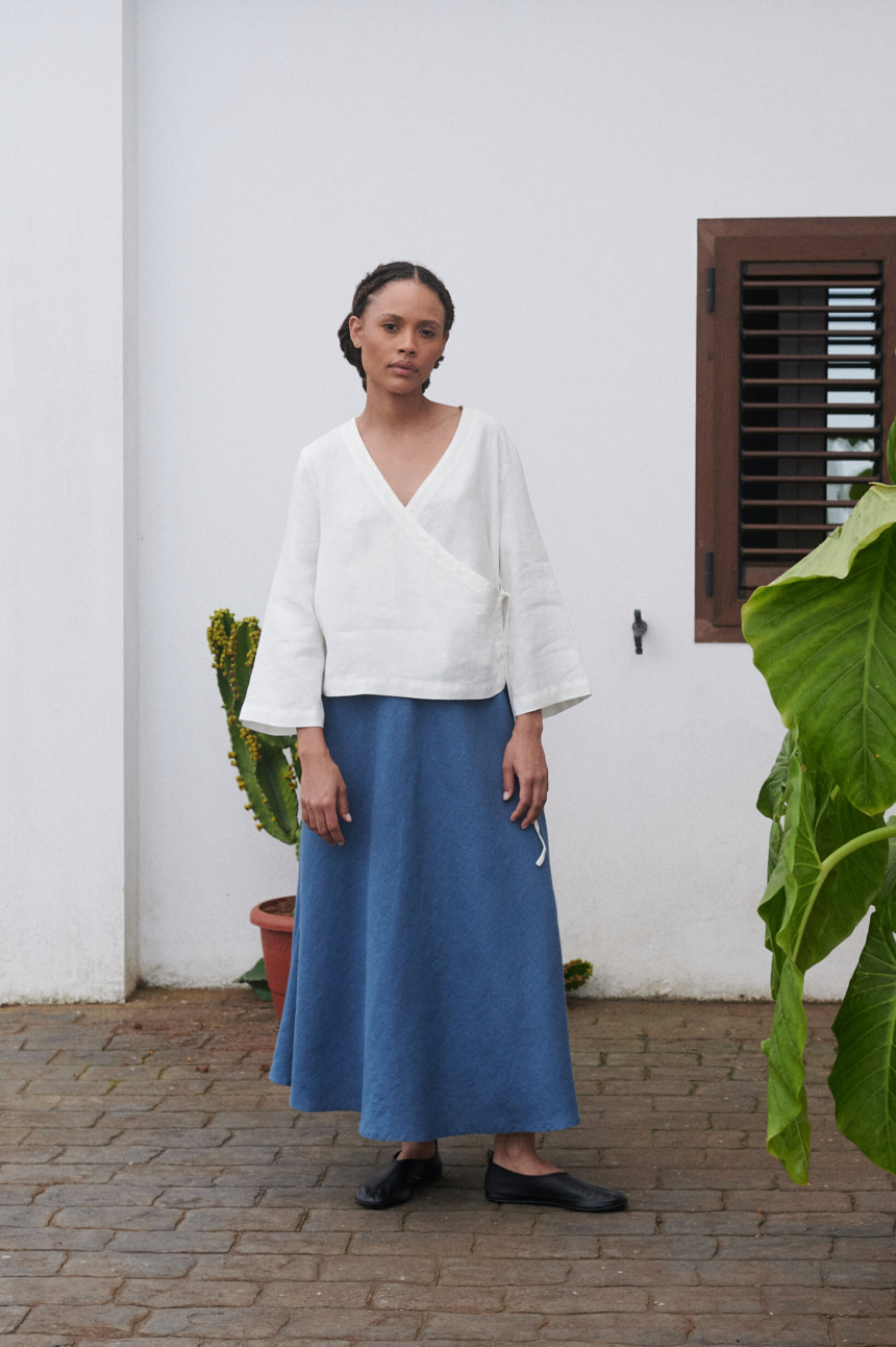 Model wearing an oversized white linen wrap top and a long blue linen skirt outfit