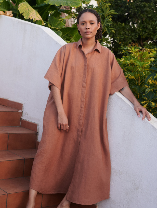 Woman wearing an oversized maxi linen dress with hidden buttons, shirt collar, and kimono sleeves in the color mocha mousse