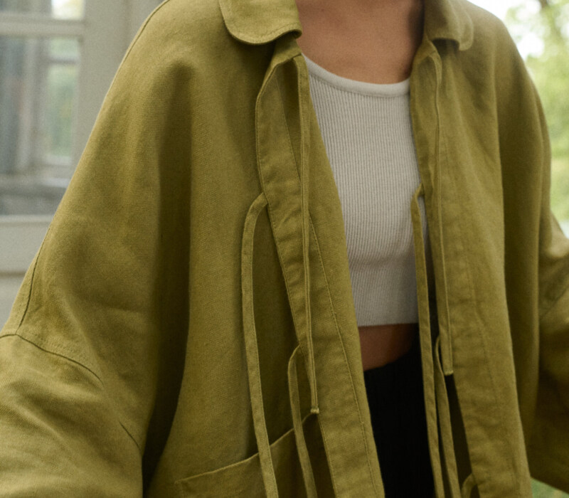 Model is wearing olive green linen jacket