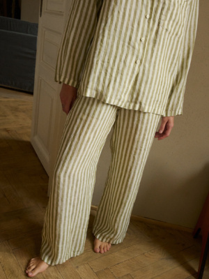 Close up of woman's pajama set of long-sleeved shirt and trousers made from high-quality olive and white stripes linen fabric.