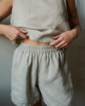 A close up of woman wearing natural grey linen nightwear set. Soft and breathable pajama shorts combined with linen tank top for the most comfort during lounging or sleeping.