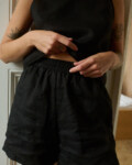 a close up of woman wearing black shorts and top made from lightweight linen fabric. A breathable set of linen nightwear and loungewear for women.