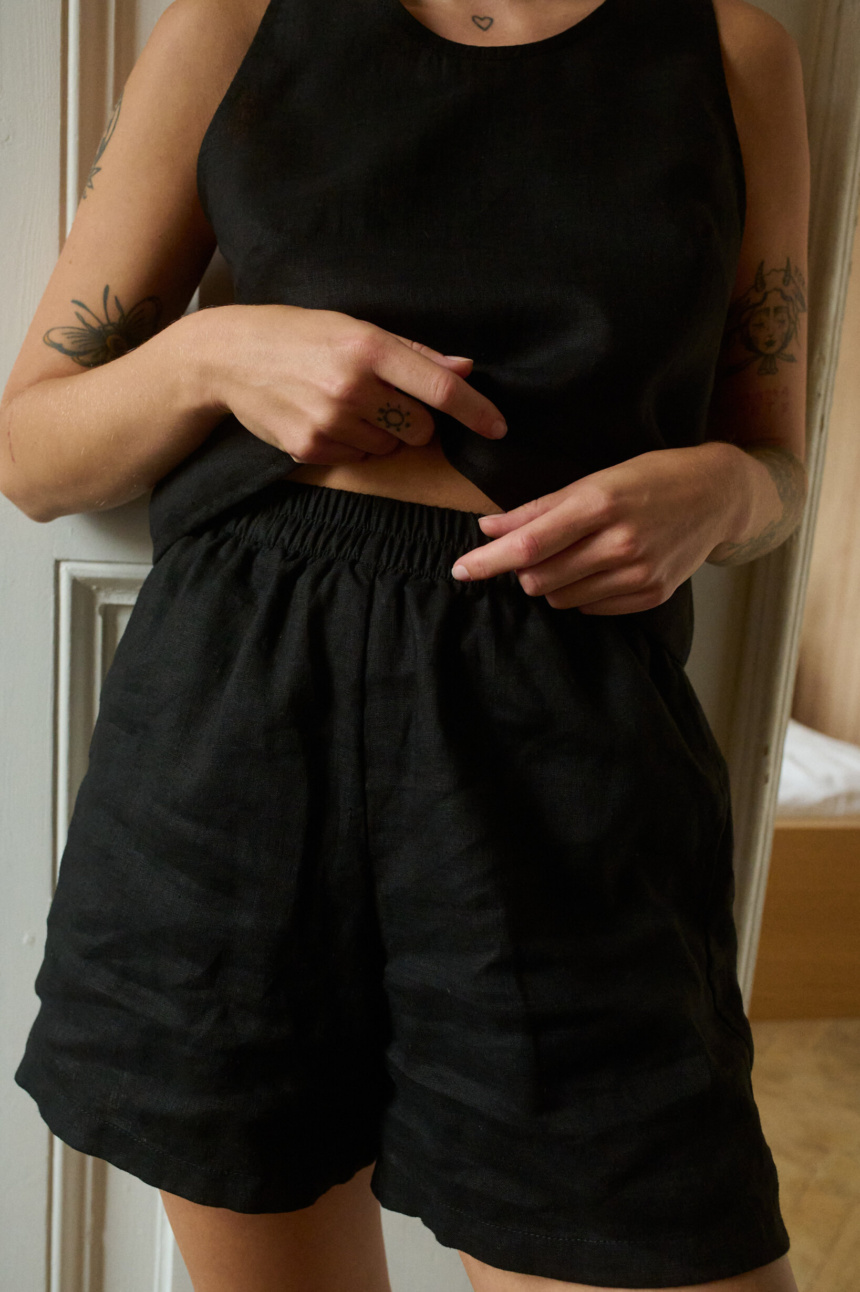 a close up of woman wearing black shorts and top made from lightweight linen fabric. A breathable set of linen nightwear and loungewear for women.