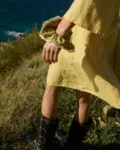 A scrunchie made from pickle checks linen fabric with white lace trim, worn on the wrist of a person