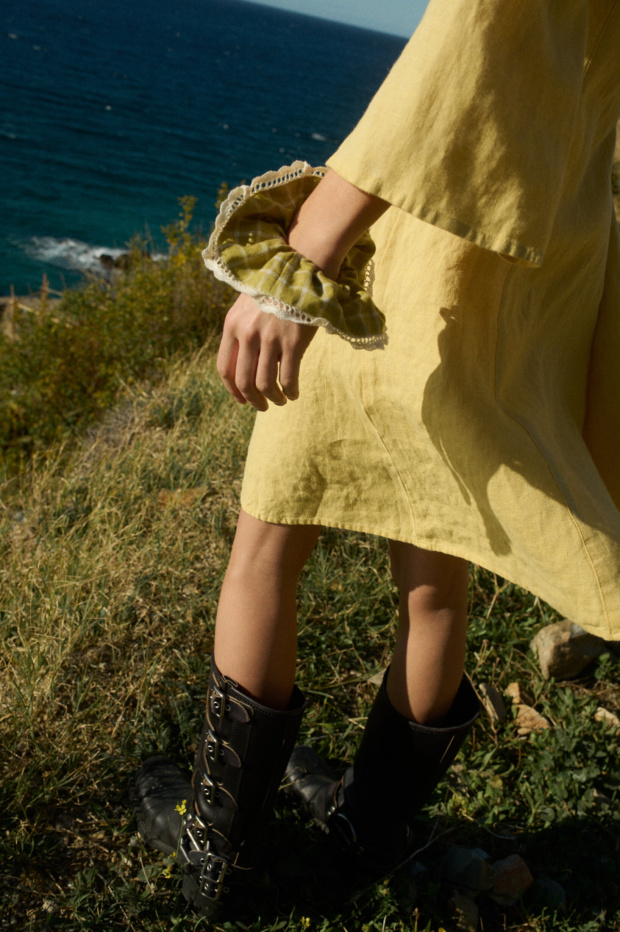 A scrunchie made from pickle checks linen fabric with white lace trim, worn on the wrist of a person