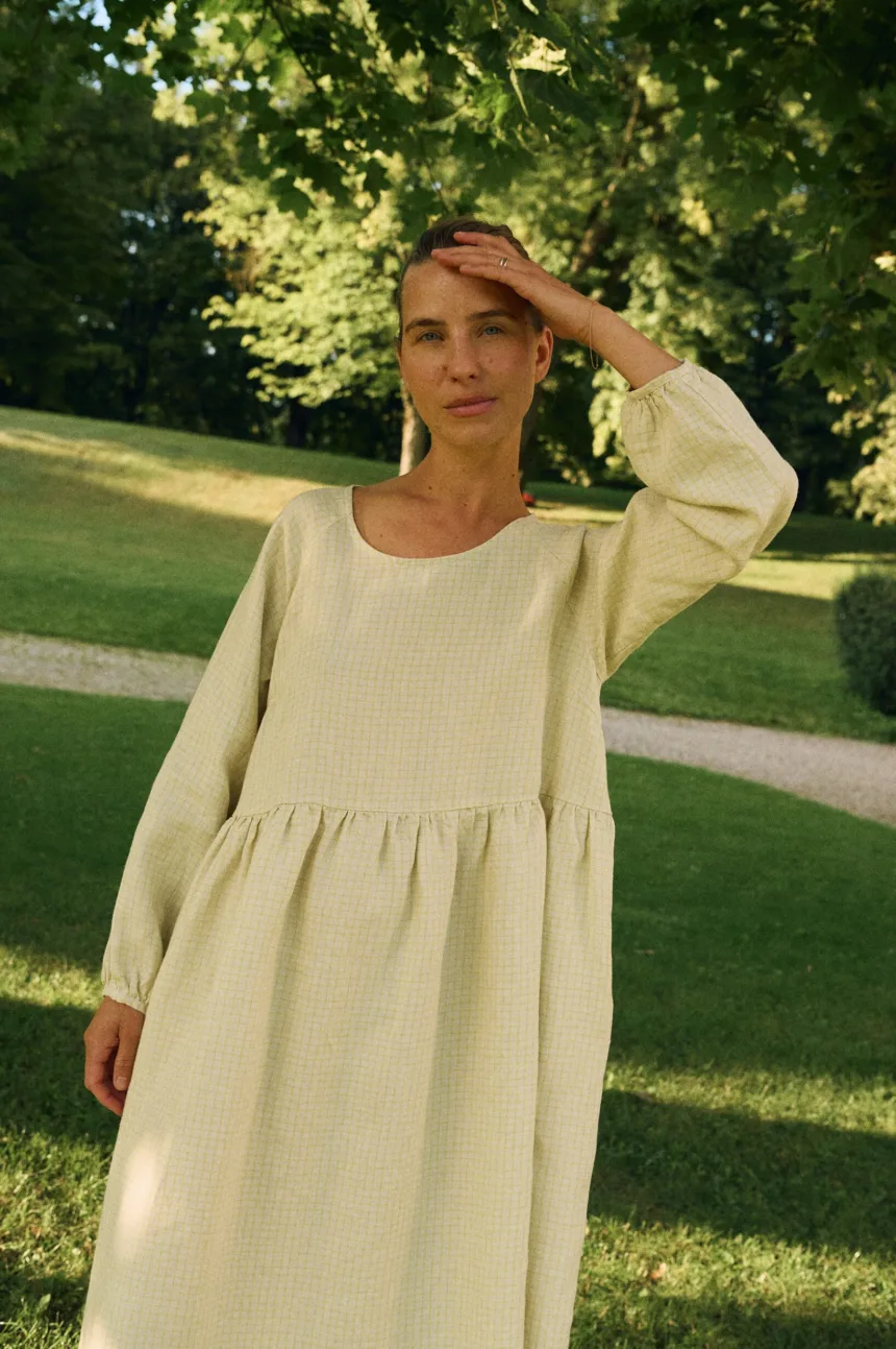 Front view of apple checks linen dress with relaxed silhouette and round neckline