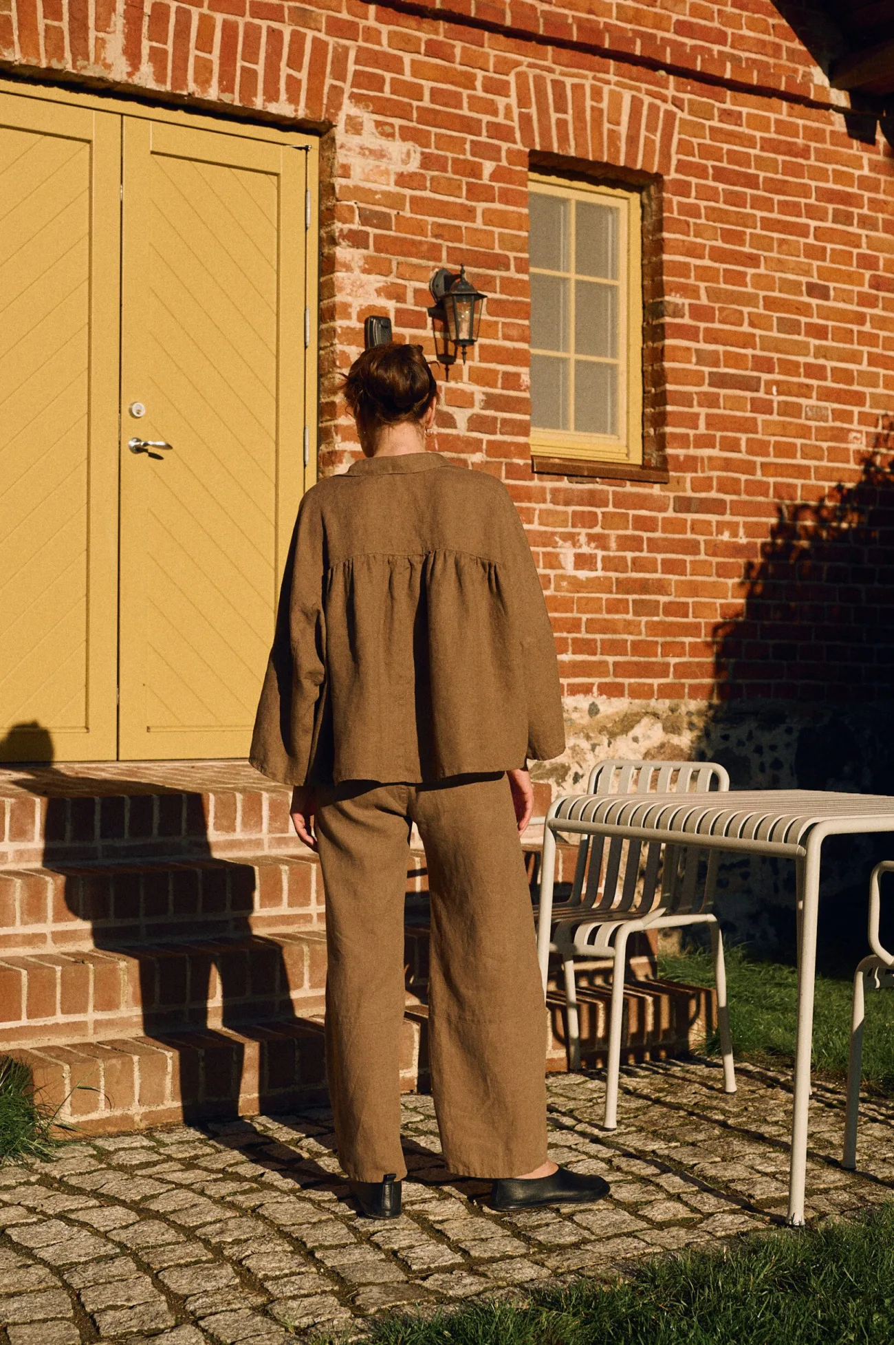 Back view of cacao linen shirt with gathered ruffle detail and relaxed drape