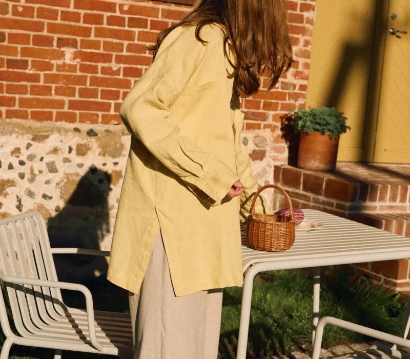 Side view of butter yellow linen shirt with relaxed oversized fit styled with natural cotton-linen pants