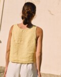 Back view of a sleeveless women’s linen top in butter yellow, featuring a relaxed fit and straight hem