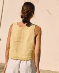 Back view of a sleeveless women’s linen top in butter yellow, featuring a relaxed fit and straight hem