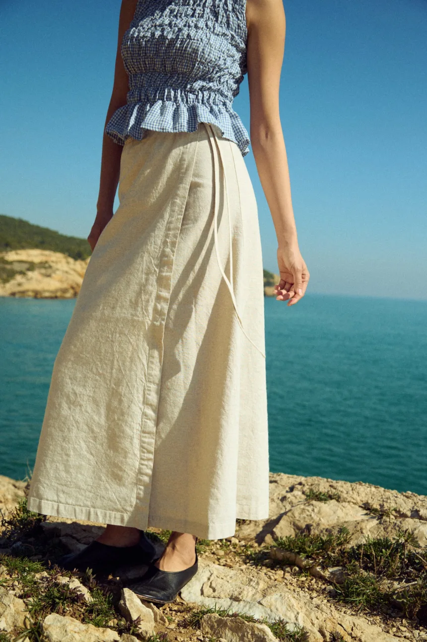 White cotton-blend wrap maxi skirt with tie closure, styled with a dusty blue mini gingham linen smocked peplum top