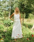 Sleeveless milky white linen set featuring a cropped button-up top paired with a high-waisted A-line wrap skirt