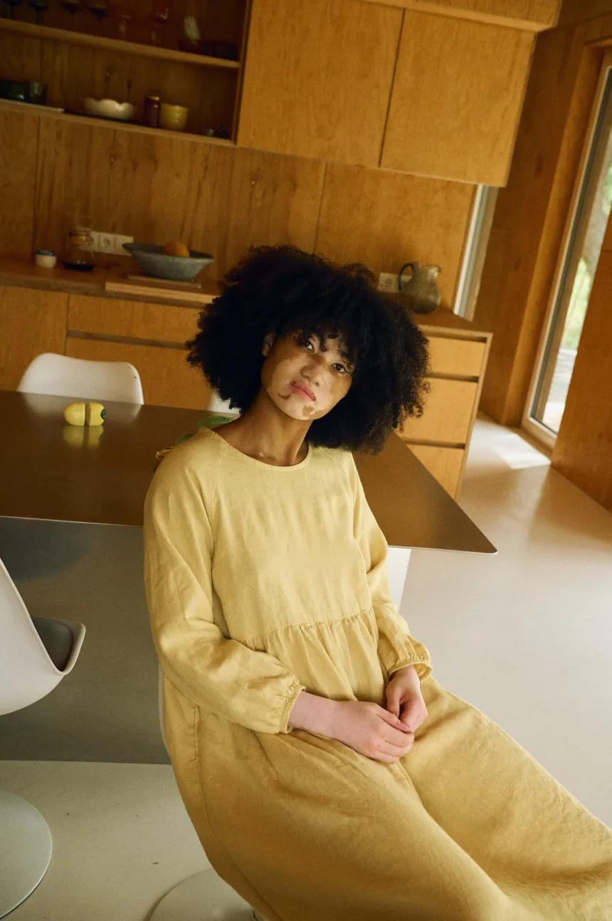 Woman sitting comfortably in the Margo oversized butter linen maxi dress