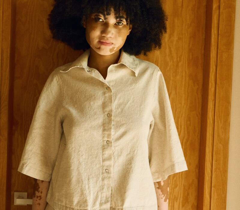 Front view of a natural-toned linen-cotton set featuring a boxy button-up shirt with wide sleeves, paired with a high-waisted midi skirt with a front slit