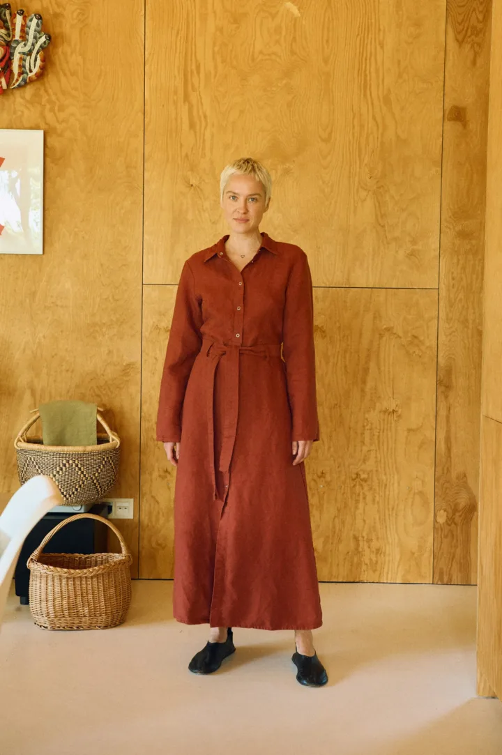 Heavy linen terracotta midi dress with collared bodice, long sleeves, and cinched belt
