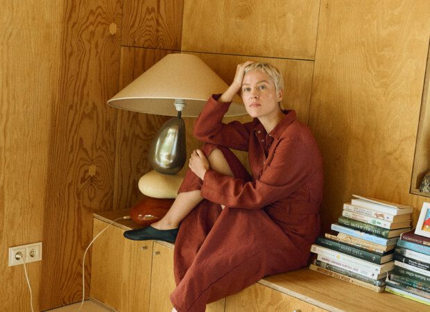 Terracotta heavy linen long sleeve button-up dress sitting pose