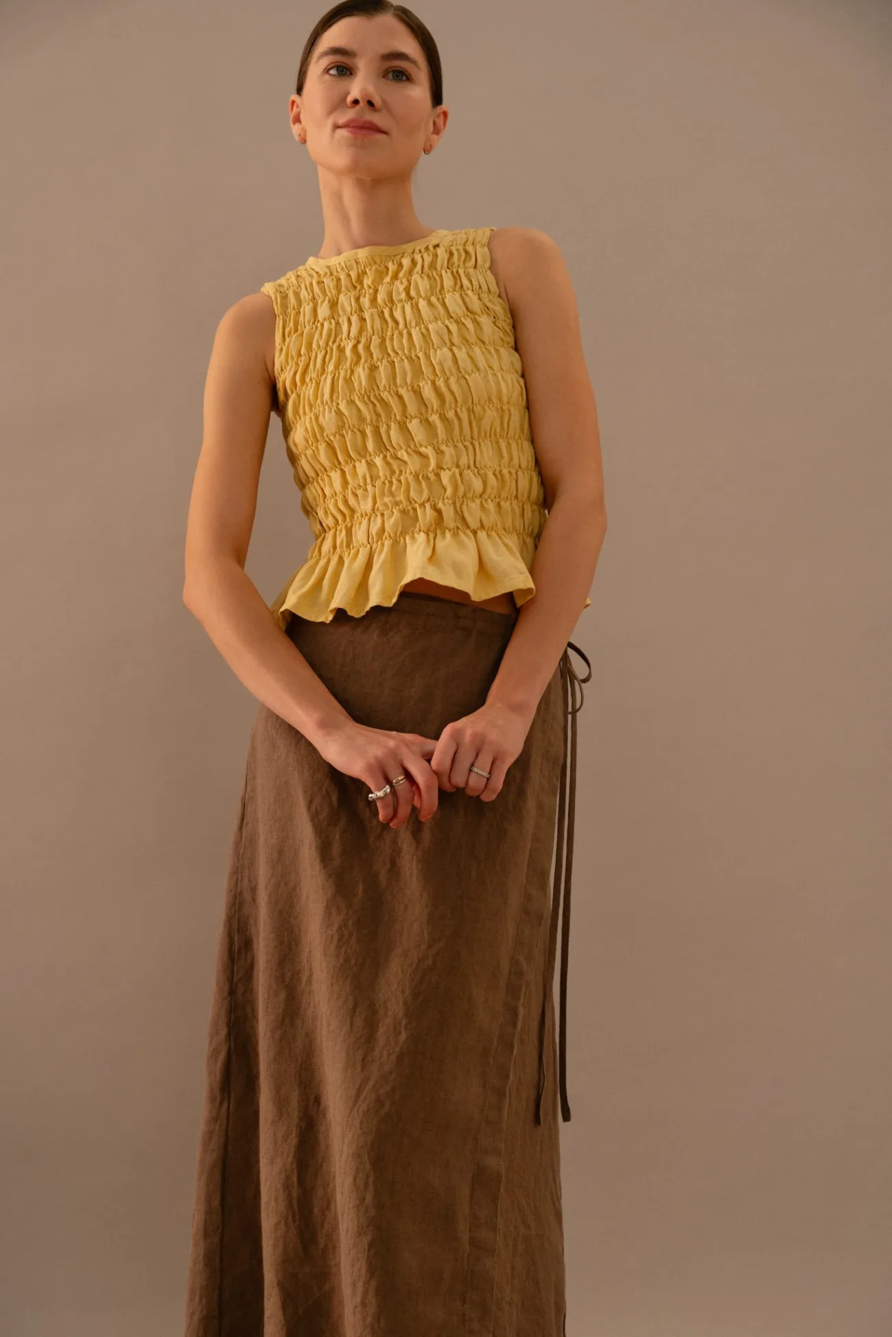 Butter yellow sleeveless smocked peplum top paired with cacao brown linen wrap maxi skirt